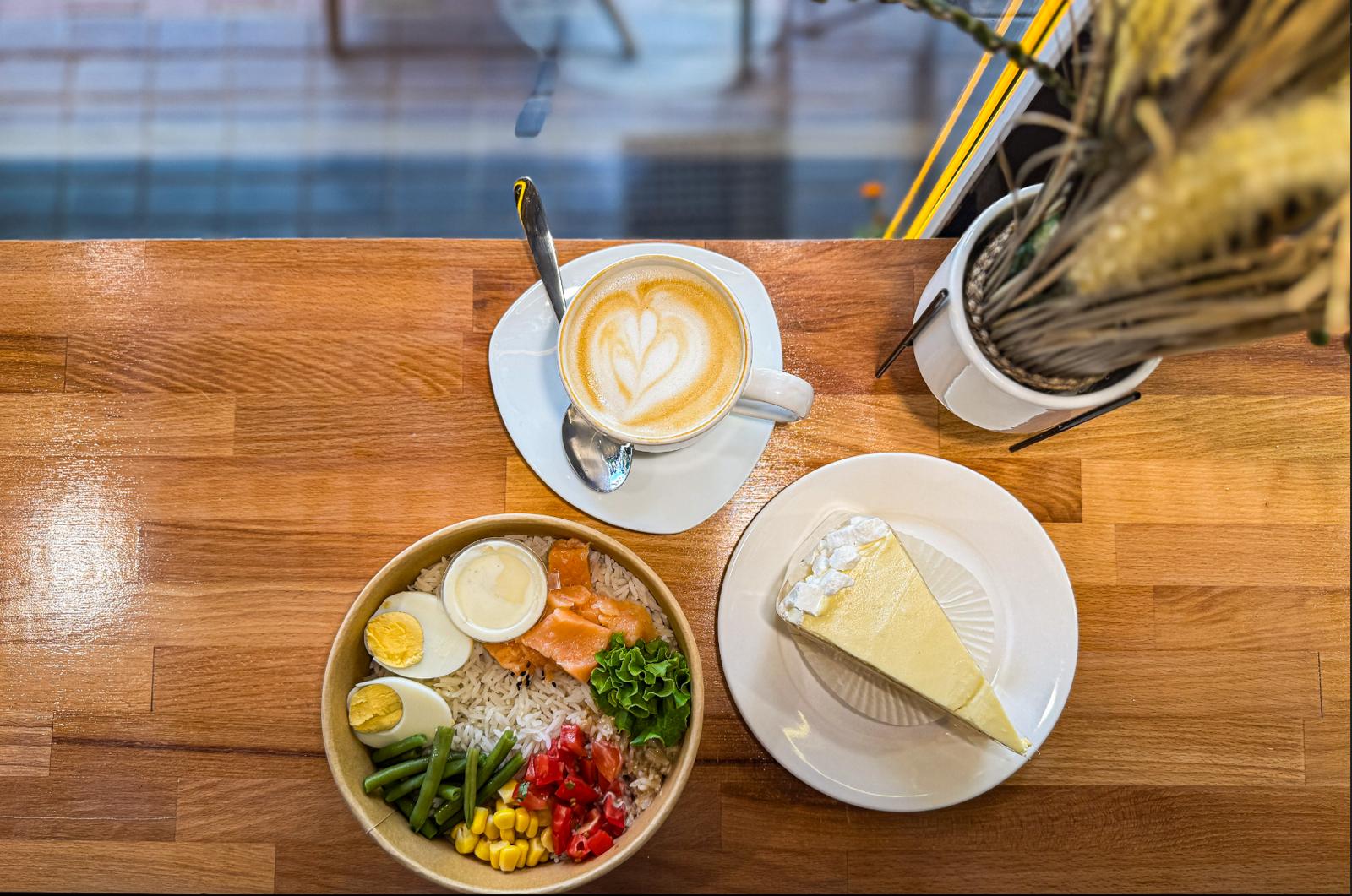 Latte art and breakfast flat lay — Sippin Coffee Almaty